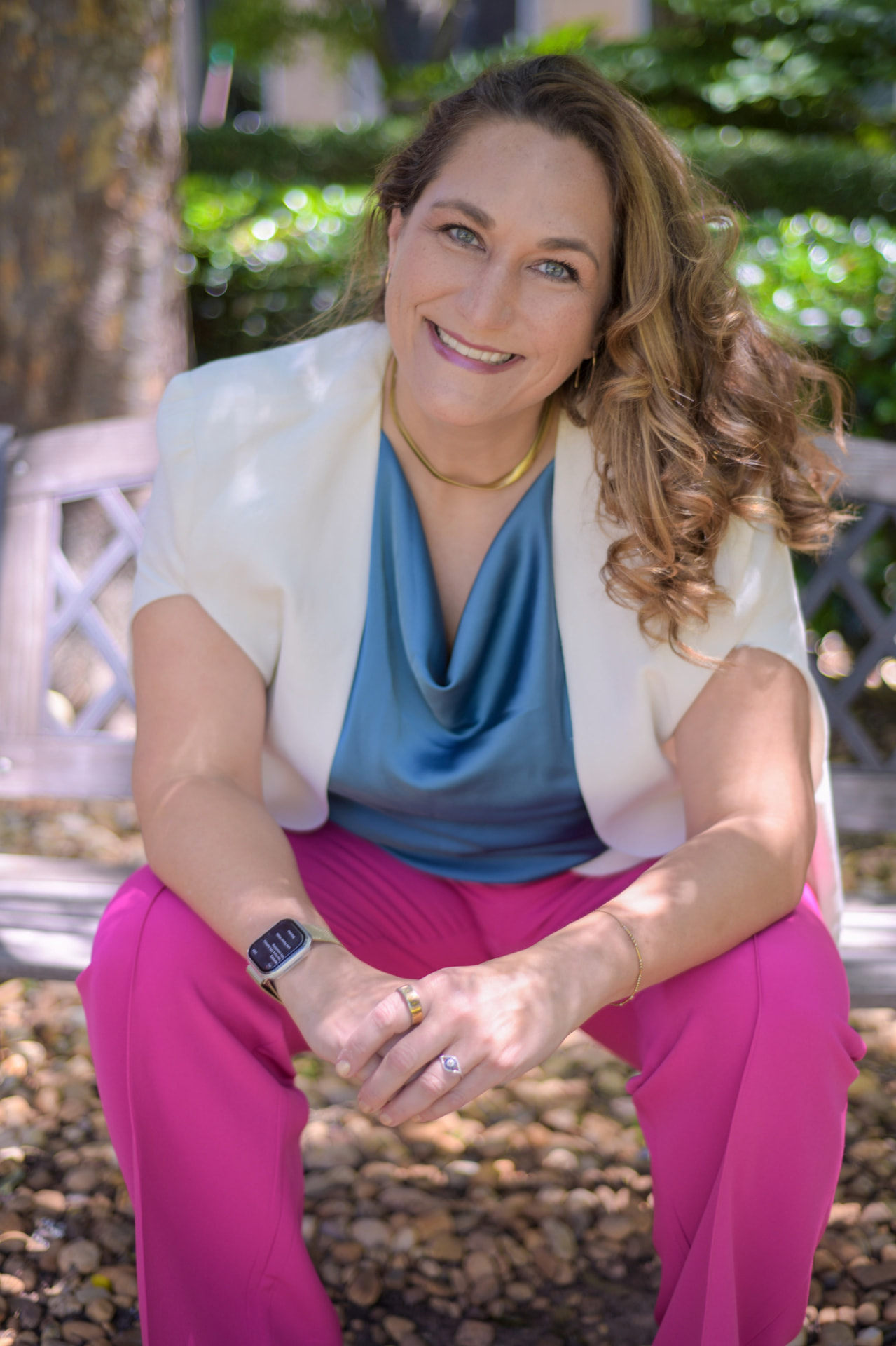 Joy St. John seated outdoors on a garden bench